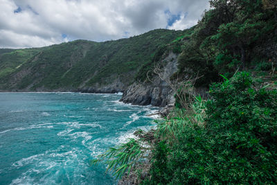 Scenic view of sea and mountains against sky