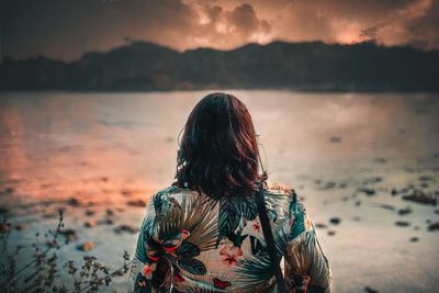 Rear view of woman looking at sea against sky