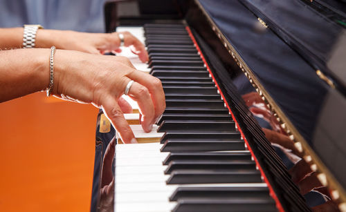 Cropped hands of woman playing piano