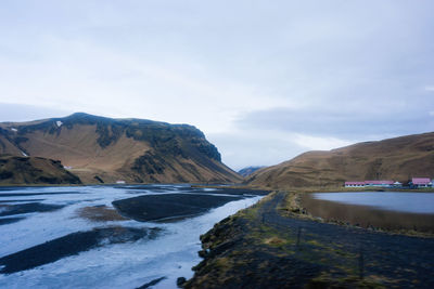 Scenic view of river amidst mountains against sky