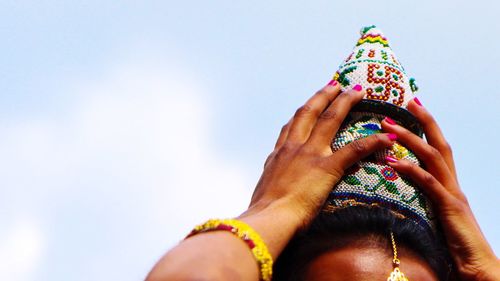 Low section of woman holding multi colored against sky