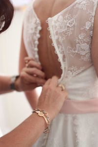 Midsection of bride getting dressed