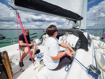 Couple sailing on a yacht. adult man and woman using a winch to pull a rope on a sailboat sail