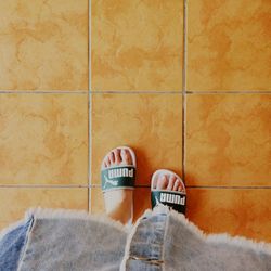 Low section of man with text on tiled floor