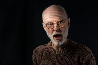 Portrait of man against black background