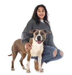 Portrait of woman with dog against white background