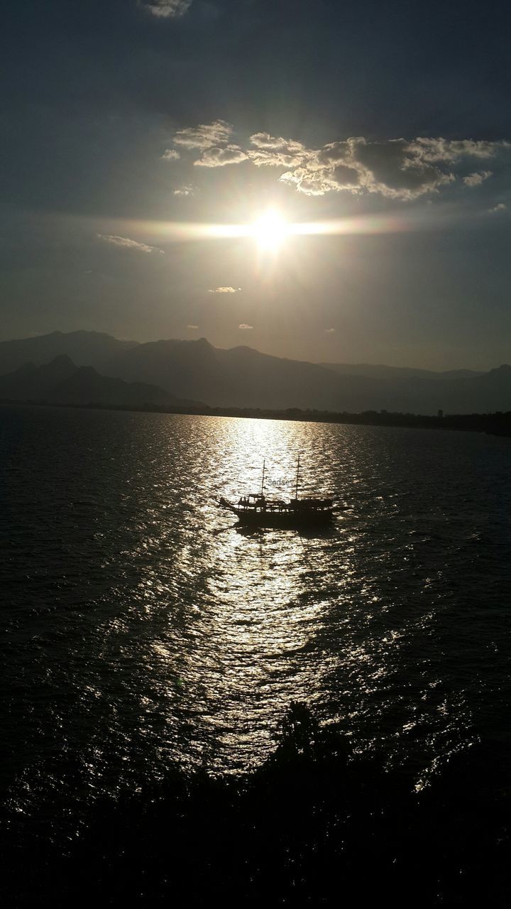 reflection, water, scenics, tranquil scene, tranquility, sunlight, beauty in nature, sea, sky, nature, sun, mountain, waterfront, seascape, sunbeam, cloud - sky, non-urban scene, dramatic sky, remote, ocean, bright, no people, majestic