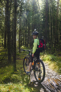 Boy cycling in forest