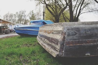 Boat moored by trees against sky