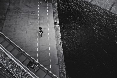 High angle view of person riding bicycle on road by sea