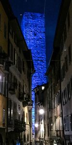 Low angle view of illuminated buildings against blue sky