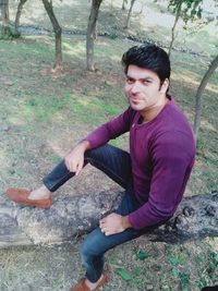 Portrait of young man sitting on land