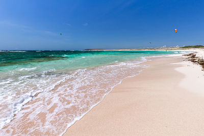 Scenic view of beach against blue sky