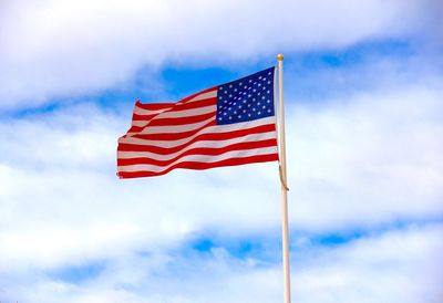 Low angle view of american flag against cloudy sky