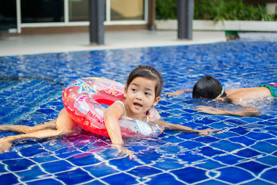 Siblings swimming in pool