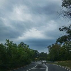 Empty road against cloudy sky