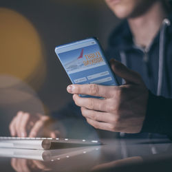 Midsection of man using mobile phone