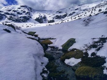 Scenic view of snow covered mountains against sky and river