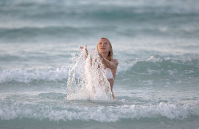 Portrait of young woman standing at beach