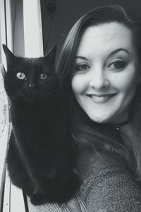 Portrait of young woman with cat at home