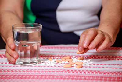 Close-up of hand holding drink on table