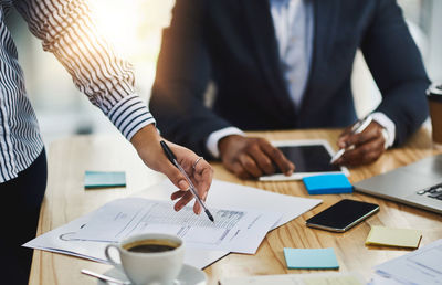 Midsection of business colleagues working on table