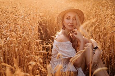 Portrait of young woman sitting on field