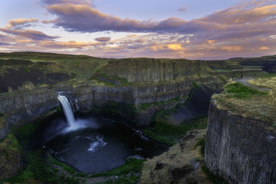 Scenic view of waterfall against sky