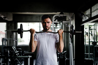 Portrait of man lifting weights in gym