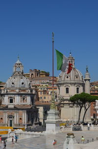 View of buildings in city against clear blue sky