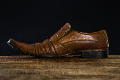 Close-up of shoes on table against black background