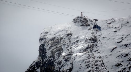 Low angle view of snow covered mountain against sky