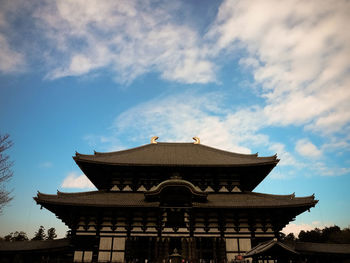 Low angle view of temple against cloudy sky