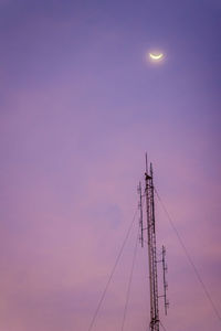 Low angle view of electricity pylon against sky during sunset