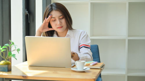 Woman sitting on table at home