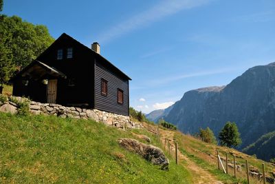 Scenic view of house and mountains against sky