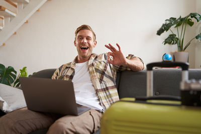 Young woman using phone while sitting at home