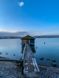 Pier over lake against blue sky