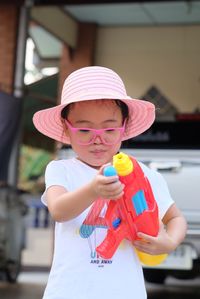 Portrait of cute girl holding hat