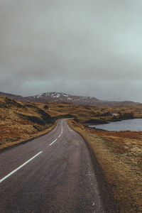 Country road against sky