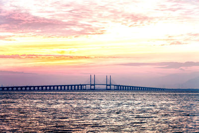 View of bridge over sea against cloudy sky