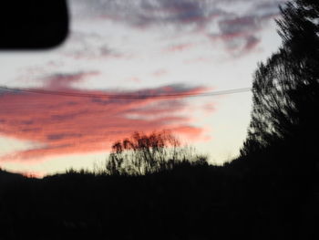 Low angle view of silhouette trees against sunset sky