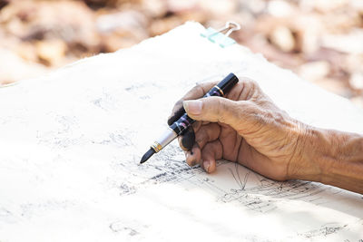 Close-up of man working on paper