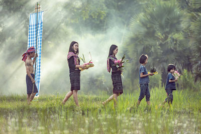 Children standing on grass against sky