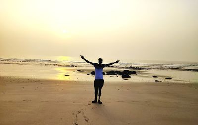 Full length rear view of woman walking on beach