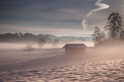 Scenic view of snow covered land against sky during winter