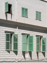 Wooden light green shutters and windows of a typical white house on the island of ibiza, spain.