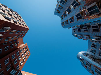 Low angle view of modern building against clear blue sky
