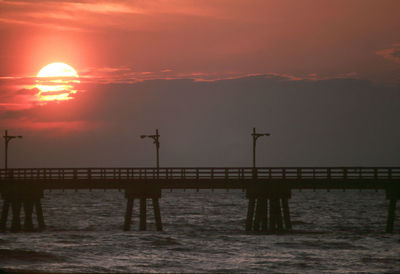 Pier on sea at sunset