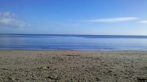 Scenic view of beach against blue sky